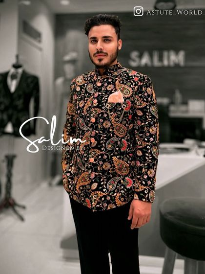 A client in a black Indo-Western jacket with a vibrant, multi-colored paisley print. This is a bold and festive piece, perfect for celebrating in style.