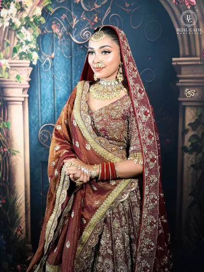 This bride looks absolutely regal with her head covered by the rich, embroidered dupatta. The makeup is designed to be flawless from every angle, ensuring she looks perfect throughout her special day.