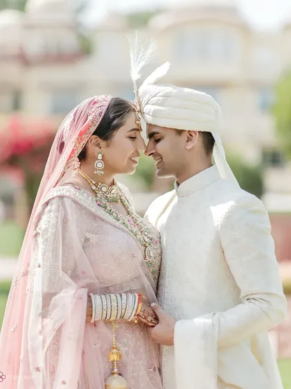 A sweet, intimate portrait of the bride and groom, their foreheads touching, capturing a quiet moment of love amidst their grand palace wedding.