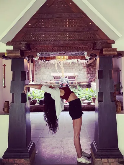 Using the beautiful architecture of a Keralan resort to support a standing backbend. This shows how we can find opportunities for yoga everywhere, blending our practice with the beauty of our surroundings.