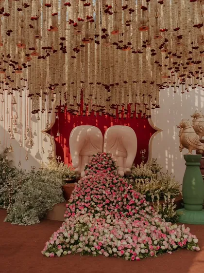 A unique seating concept for the couple, shaped like a pair of cupped hands (Anjali mudra), overflowing with flowers. This bespoke piece is a beautiful symbol of offering and togetherness.