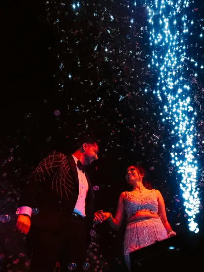 A dramatic shot of the couple under a cascade of sparklers and confetti, their hands joined, celebrating their love.