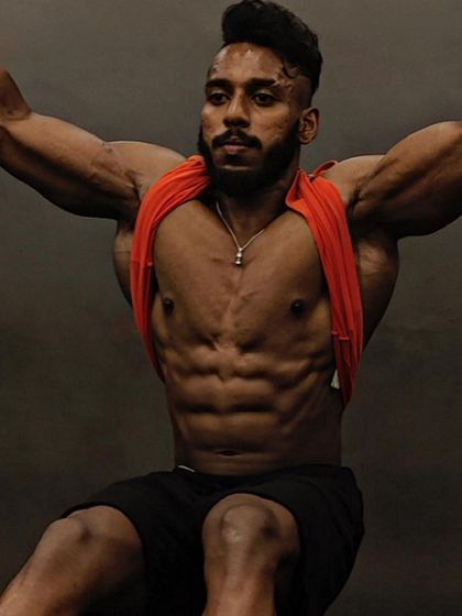 The "after" shot, showcasing a shredded and muscular physique. This client is a men's physique competitor who successfully completed a bulking and cutting cycle.