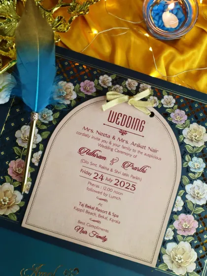 A close-up of a laser-cut floral invitation, where the arched insert is framed by a border of three-dimensional flowers.