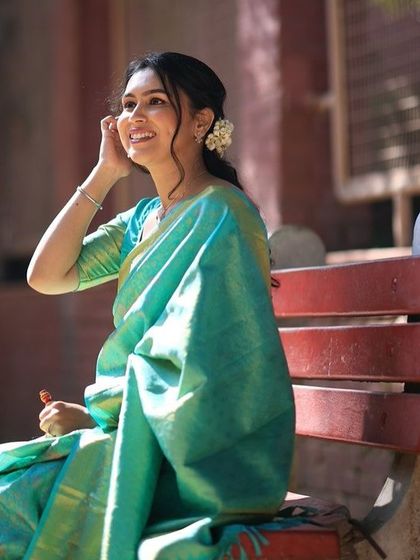 A candid smile that lights up the frame. This close-up shows the fresh makeup and the delicate gajra in her hair, perfect for a traditional ceremony.