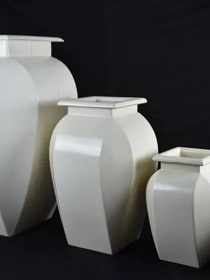 A set of elegant, white fiber planters in various sizes. Their classic shape makes them suitable for any decor style.