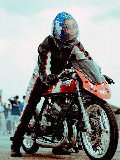 A rider on a custom drag bike, focused and ready at the starting line. The tension and anticipation before the lights go green is a palpable part of the experience.