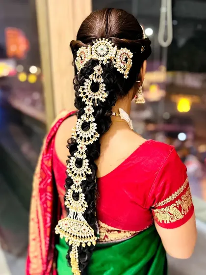 A stunning view of the traditional South Indian bridal braid, heavily decorated with beautiful temple jewelry hair accessories.
