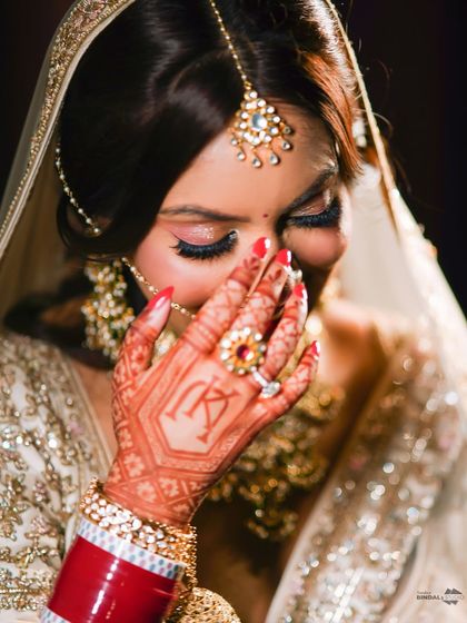 A shy, happy smile from the bride. This close-up focuses on her beautiful henna, with her initials cleverly hidden in the design, and her joyful expression.