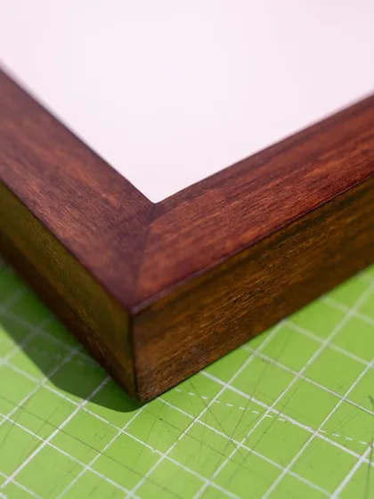The fine craftsmanship of a mitered corner on one of the solid wood frames we use for our custom framing services.