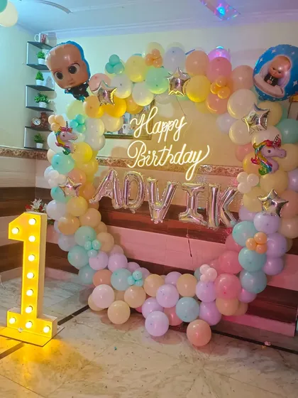 A pastel-colored Boss Baby theme for a first birthday. This gentle color scheme is great for younger kids, complete with a full balloon ring and a light-up number.
