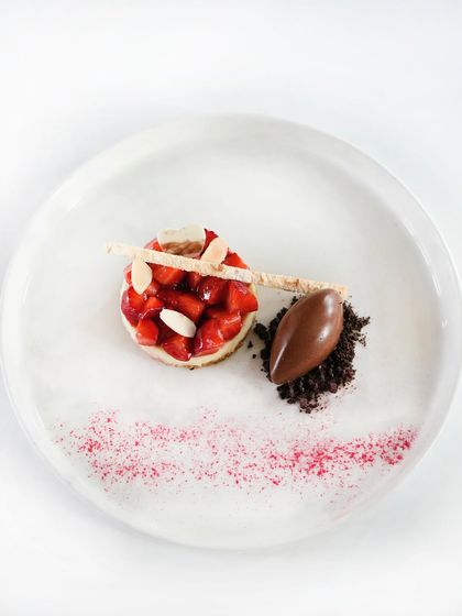 A beautiful dessert of fresh strawberries and almonds on a cheesecake base, served with a quenelle of 64% Manjari chocolate. A perfect balance of fruit, cream, and chocolate.