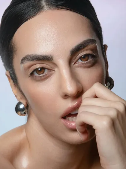 A playful expression captured with a focus on dewy skin and glossy lips. This demonstrates my ability to create makeup that looks great from every angle and allows for natural movement.