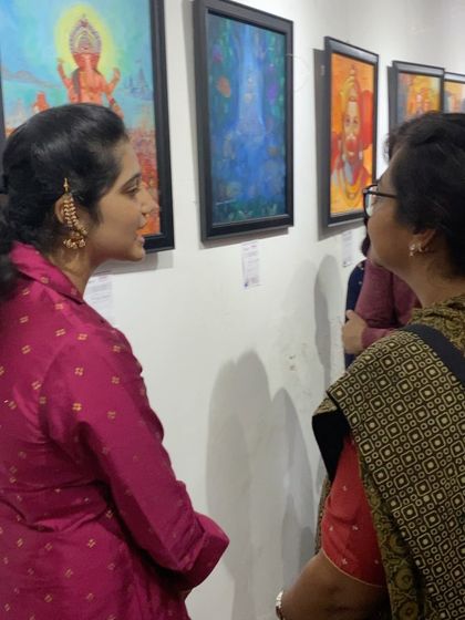 An artist discussing her work with an attendee at the exhibition. These interactions are invaluable for growing artists.