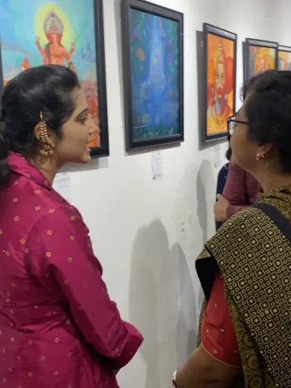 An artist discussing her work with an attendee at the exhibition. These interactions are invaluable for growing artists.