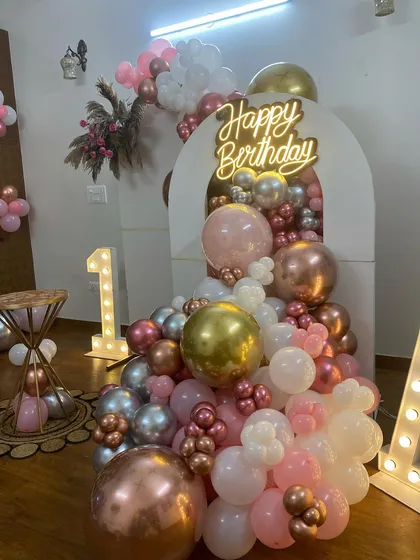 This is a duplicate of ID 22, 69, 160, 214, 252. A stylish and modern first birthday decoration for a home party. This setup features a balloon cascade in rose gold, pink, and white, a 'Happy Birthday' neon sign, and large marquee letters.