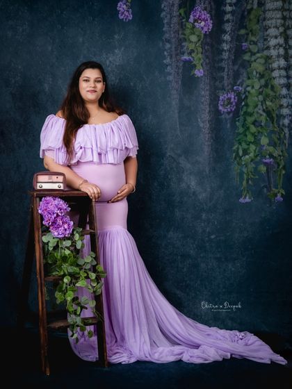 A rustic-chic setup with a lavender gown. The wooden ladder and hanging purple flowers create a beautiful, themed look.