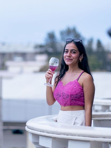 A guest enjoys a glass of wine on the balcony, taking in the view and the elegant atmosphere.