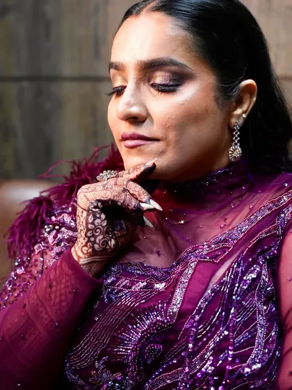 A close-up showing the intricate details of her henna and the dramatic eye makeup.