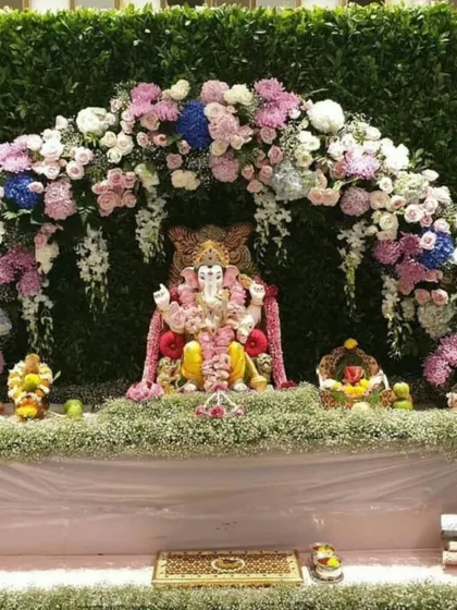 This beautiful setup creates a floral paradise for Bappa, with a dense arch of fresh flowers and a bed of baby's breath.