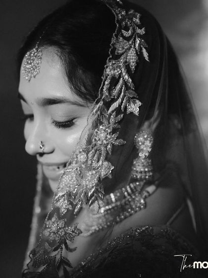 A delicate black and white close-up of the bride. The focus on her embroidered veil and serene expression creates a soft, intimate, and timeless portrait.