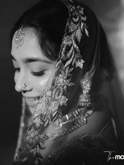 A delicate black and white close-up of the bride. The focus on her embroidered veil and serene expression creates a soft, intimate, and timeless portrait.