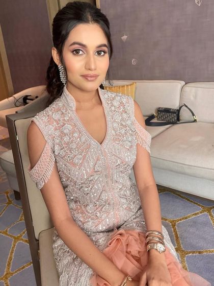 A gorgeous look for a sister's reception, featuring soft pink makeup and a chic ponytail.