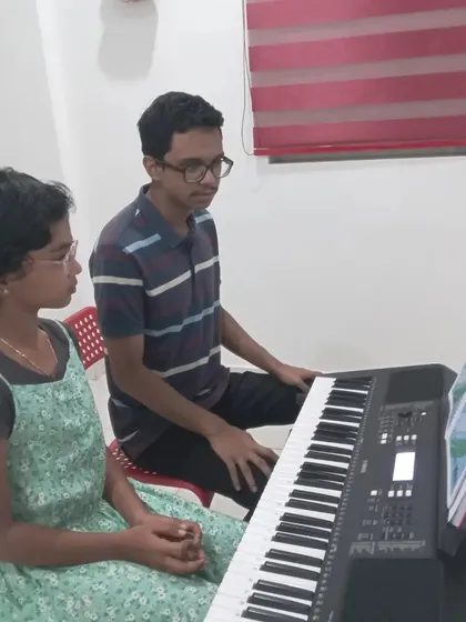 A keyboard student learning alongside her instructor. This side-by-side guidance helps in correcting techniques in real-time.