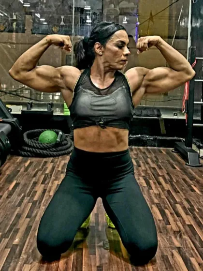 A classic double biceps pose in the gym. This is the result of countless hours and a personalized nutrition plan, showing the muscle definition required to impress the judges.