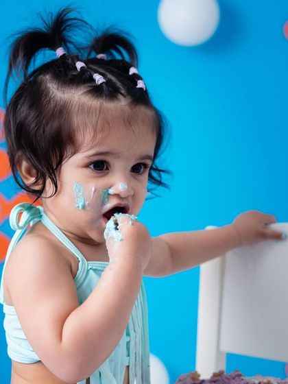 Getting her hands right into the cake. This is a sensory experience for the baby, and I capture their exploration and delight.