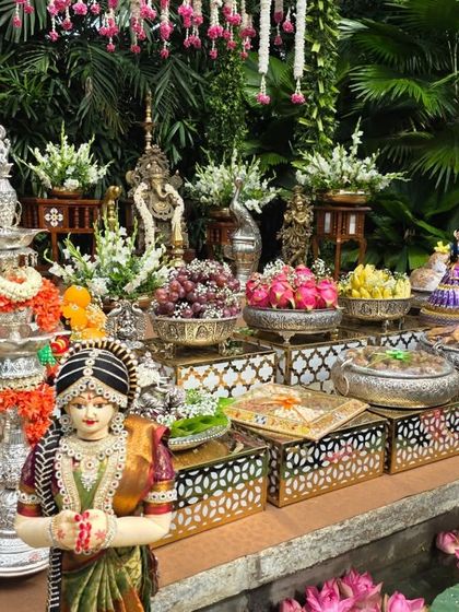 A close-up of the offering table at the outdoor ceremony, featuring silver props, traditional dolls, and a small pond with lotus flowers.