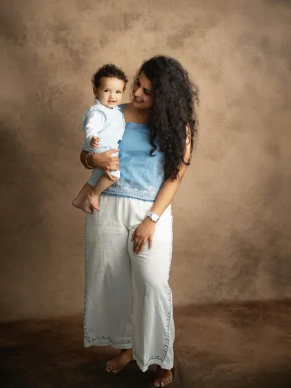 A full-length portrait of mother and child, showcasing their coordinated outfits against a classic studio backdrop. These are the portraits that become family heirlooms.