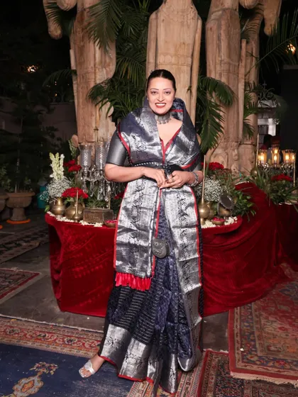 A modern take on Rajputi royalty. This look, styled for a maximalist-themed evening, features a navy and silver Banarasi saree paired with a unique silver stole draped around the neck for a regal effect. The oxidized jewelry adds a layer of heritage to the ensemble.