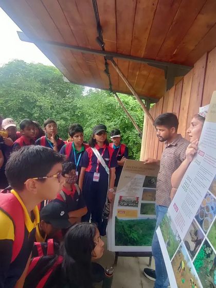 Our team uses informational posters to explain the history and progress of the Aravalli Biodiversity Park restoration to the students.
