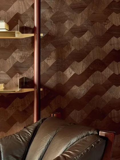A close-up of a wall featuring a dynamic, wave-like pattern created from wood marquetry. This design transforms wood into a fluid, elegant surface, showcasing the artistry and precision of our high-end wallcovering collections.