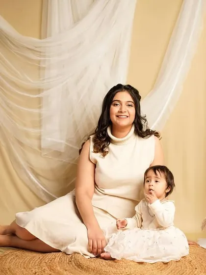 A lovely portrait of a mother and her daughter. The matching neutral tones and serene studio backdrop create a classic and elegant image.