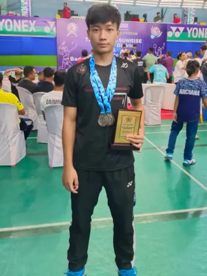 **State Open Championship Medalist.** Martin proudly displays his silver medal and plaque from the U-17 Boys' Doubles event at the 68th State Open.
