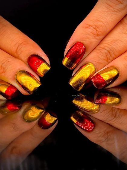 A bold color-blocked design with metallic red and gold chrome on short nails.