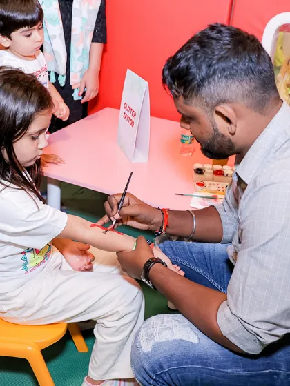A glitter tattoo station in action. These fun and temporary tattoos are always a popular activity at our parties, letting kids express their style.