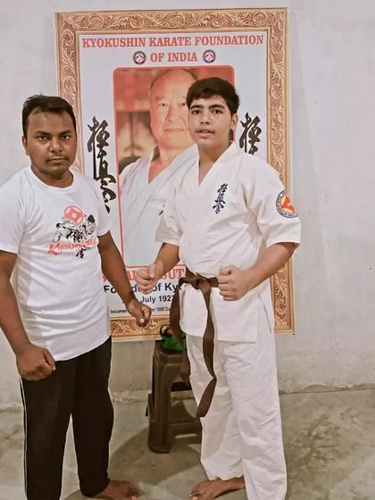 This young man has earned his brown belt. He stands proudly with me after the ceremony.