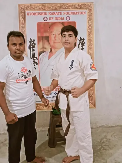 This young man has earned his brown belt. He stands proudly with me after the ceremony.