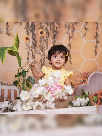 This shot shows the variety of props used in our sunflower theme, including a miniature white picket fence, floral arrangements, and hanging greenery.