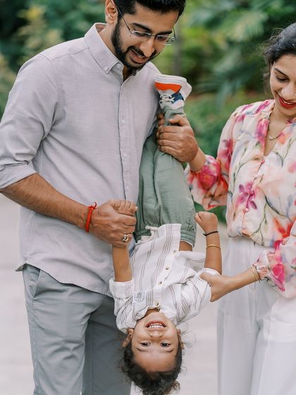A father holding his son upside down. The laughter and trust between them are wonderful to see.