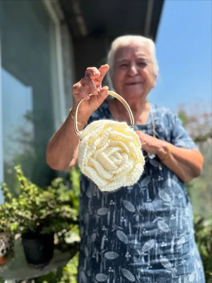 Dadi holding the white Rose bag. It's a perfect example of the beautiful, high-quality work our grannies do.