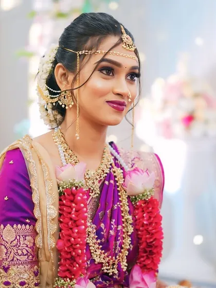 The bride during her wedding ceremony, wearing a garland of fresh flowers. Her makeup is waterproof and designed to last through all the rituals.