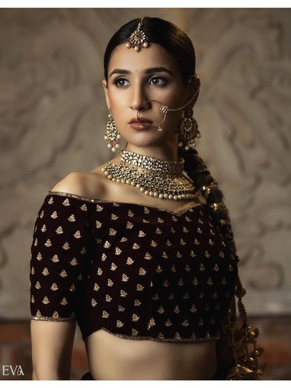 A classic medium shot of the model in an off-shoulder velvet blouse. The direct gaze and poised stance make this a strong image for a bridal fashion catalogue.