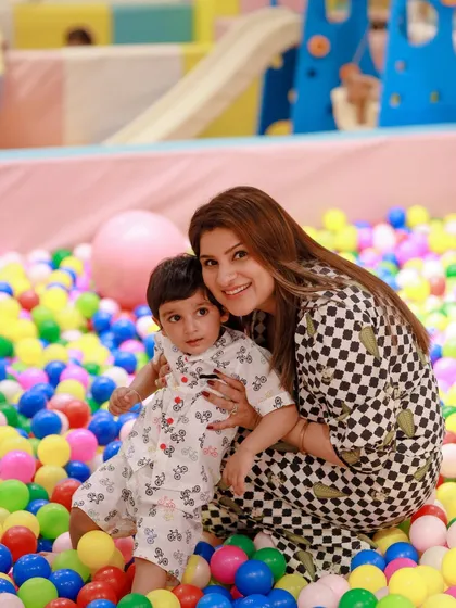 A mother and son enjoying a sweet moment during a barnyard-themed second birthday party in our colorful ball pit.