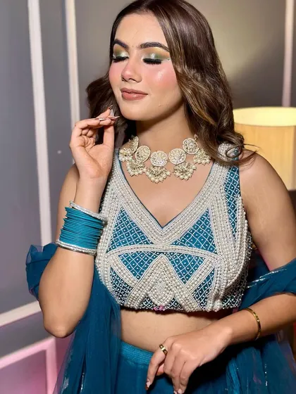 A vibrant and fresh look perfect for a sangeet or mehendi ceremony. I used a pop of green and gold on the eyes to match her teal lehenga, paired with soft waves and a dewy skin finish.