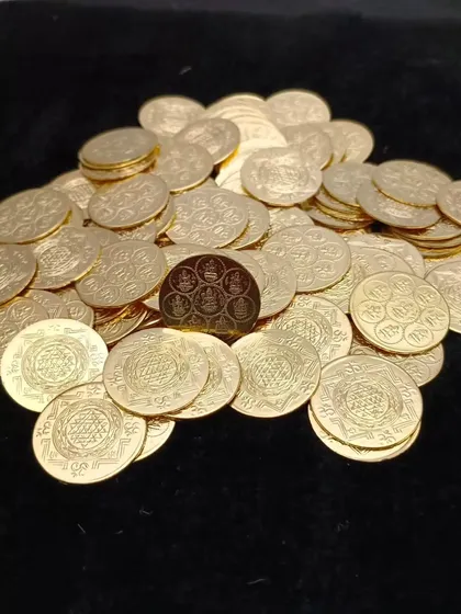 A pile of gold-colored German silver Lakshmi coins, perfect for using in poojas or including in gift bags for prosperity.
