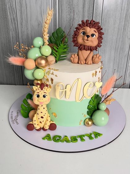 A full view of the jungle cake for Agastya's first birthday, showing the beautiful balance of cute characters and modern design elements.